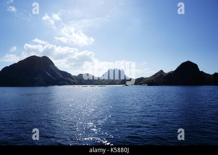 Küste von Bergen und einem kleinen weißen Sandstrand im blauen Ozean Wasser in Labuan Bajo, Flores, Indonesien. Stockfoto