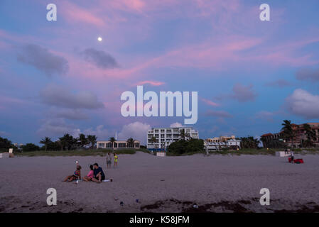 Delray Beach, Florida, USA. 8. Sep 2017. Menschen sitzen und den Strand bei Sonnenaufgang genießen und den Mond in Delray Beach, Fla., septembert. 08, 2017. Irmas tracking hat gezeigt Ihr LANDFALL an der südlichen Küste Floridas zu machen von diesem Wochenende. Credit: Ken Cedeño/ZUMA Draht/ZUMAPRESS.com/Alamy leben Nachrichten Stockfoto