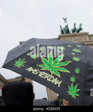 Berlin, Deutschland. 9 Sep, 2017. Ein Mann trägt einen Regenschirm mit Bildern von Marihuana Blätter vor dem Brandenburger Tor in Berlin, Deutschland, 9. September 2017. Foto: Paul Zinken/dpa/Alamy leben Nachrichten Stockfoto