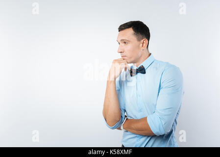 Schöne nachdenkliche Mensch sein Kinn Holding Stockfoto