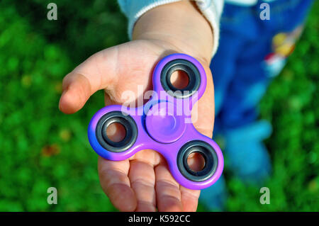 Hält die Spinner in seiner Hand. Stockfoto