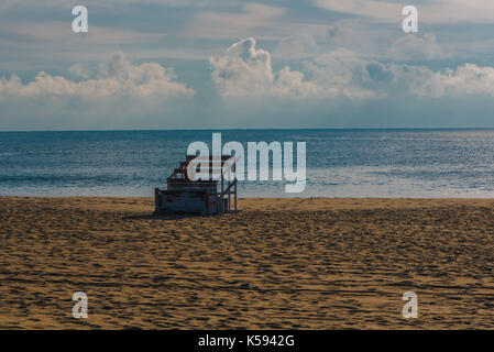 Ein Bademeister Stuhl auf Ihrer Seite auf den Strand am frühen Morgen. Stockfoto