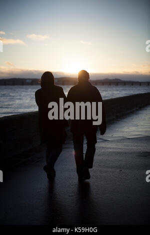 Paar Hände halten, wandern am Fluss Tay, Broughty Ferry, Dundee, Schottland Stockfoto