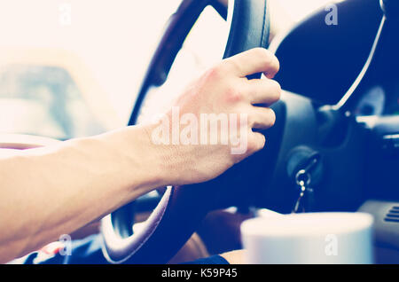 Treiber griffe Lenkrad im Fahrzeug während der Fahrt im Verkehr. authentisches Bild von Reisen. Stockfoto