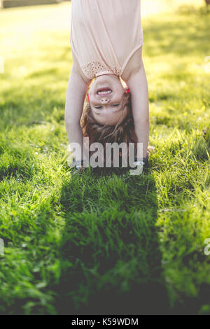 Glückliches Kind spielen auf grünem Gras im Freien in Spring Park Stockfoto