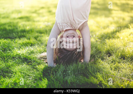 Glückliches Kind spielen auf grünem Gras im Freien in Spring Park Stockfoto