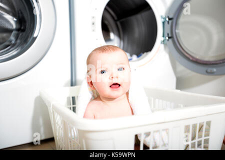 Portrait einer adorable Baby in einen Wäschekorb sitzen Stockfoto