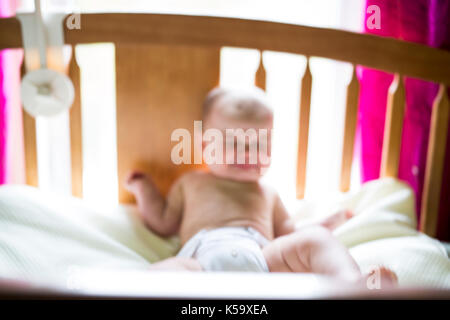 Verschwommenes Bild von einem weinenden Baby girl im Schlafzimmer Stockfoto