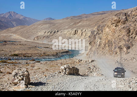 4WD Fahrzeuge fahren auf der Pamir Highway/M41 entlang der Pamir Fluss in der Provinz Gorno-Badakhshan, Tadschikistan Stockfoto