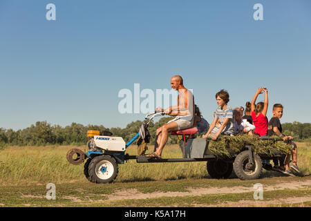 - KONCHA ZASPA, UKRAINE - Juli 30, 2017: unbekannter Mann rollen Kinder auf einem mini Traktor. Koncha-Zaspa ist ein historisches Viertel von Kiew. In den 192 Stockfoto