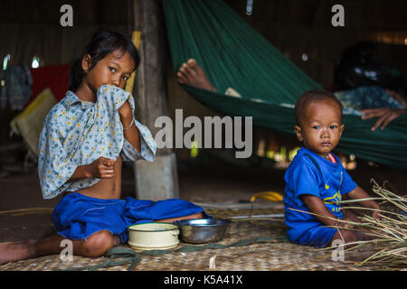 SIEM REAP, Kambodscha - 9/12/2015: Zwei Geschwister auf dem Boden ihres Dorfes zu Hause sitzen. Stockfoto