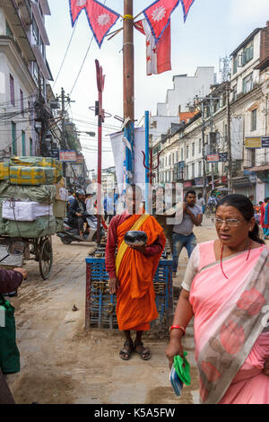 KATHMANDU, Nepal - 9/26/2015: Ein buddhistischer Mönch sammelt Spenden in der Nähe des Durbar Square im Thamel Bezirk von Kathmandu, Nepal. Stockfoto