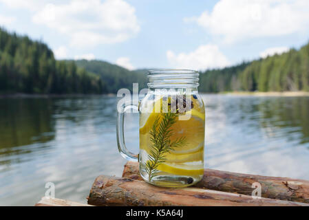 Infundiert Wasser auf einem Pier mit Zitrone Heidelbeeren Piniennadeln und Kegel Stockfoto