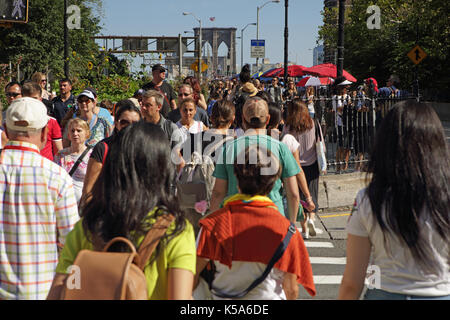 Massen von Touristen zu Fuß über die Brooklyn Bridge an einem sonnigen Tag der Arbeit Urlaub Stockfoto
