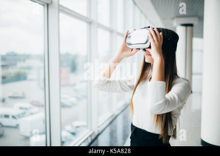 Aufgeregt, Lächeln, Geschäftsfrau, tragen Virtuelle Realität Gläser, glückliche Frau Erkundung augmented World, Interaktion mit digitalen Schnittstelle während standin Stockfoto
