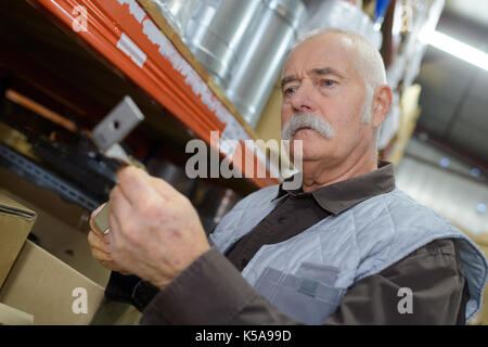 Mann Entnahme eines Teils aus dem Regal im Lager Stockfoto