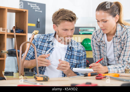 Weibliche auszubildende Klempner Arbeiten an zentralen Heizkessel Stockfoto