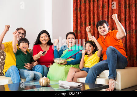 Happy Indischen große Familie watching Cricket Match auf Tv Erfolg Fest zu Hause Stockfoto