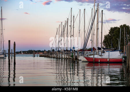 Marina in Venedig, Yachten, Segelboote, Matrosen und verschwommenes Mast formen Reflexionen auf dem Wasser. Romantische Landschaft. Sommer Urlaub in Italien. Stockfoto