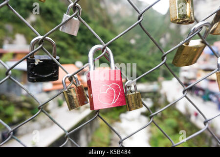 Rote herzförmige lock Schloss auf dem Zaun im Hintergrund Stockfoto