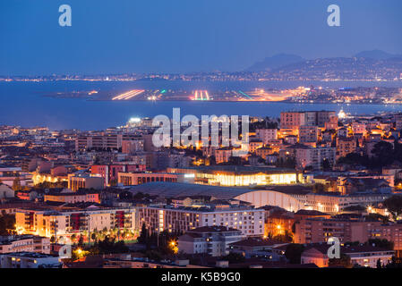 Erhöhte Aussicht auf die Dächer von Nizza in der Dämmerung mit den Start- und Landebahnen in der Ferne. Französische Riviera, Provence-Alpes-Cote d'Azur, Frankreich Stockfoto