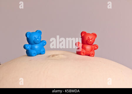 Rot und Blau Kunststoff Spielzeug Bär auf schwangeren Bauch Stockfoto