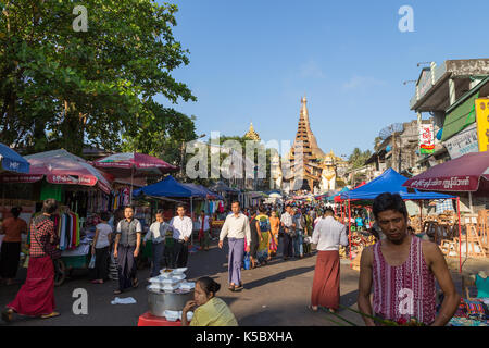 Die Shwedagon Pagode östlichen Eingang und eine Menge Leute auf einem Markt auf der Gyar Tawya Straße in Yangon, Myanmar. Stockfoto