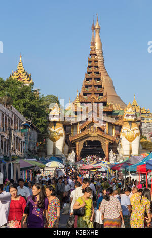 Die Shwedagon Pagode östlichen Eingang und eine Menge Leute auf einem Markt auf der Gyar Tawya Straße in Yangon, Myanmar. Stockfoto