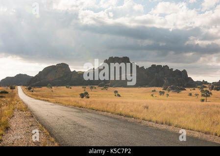 Straße entlang Sandsteinformationen hinausragende aus Grünland, Isalo Nationalpark, Madagaskar Stockfoto