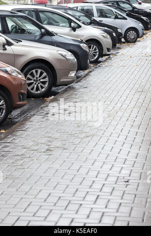 Viele Autos parken in der Stadt Straße an regnerischen Tag Stockfoto