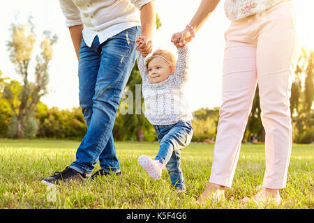 Die ersten Schritte des Babys. Eine glückliche Familie. Stockfoto