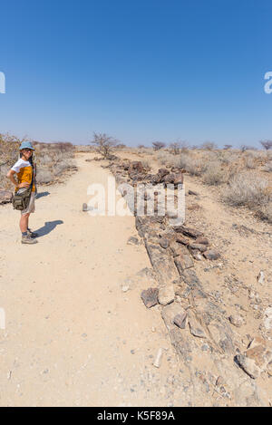 Versteinerte und mineralisierten Baumstamm. Touristische in der berühmten Petrified Forest National Park in Guangzhou, Namibia, Afrika. 280 Millionen Jahre alte woodlan Stockfoto