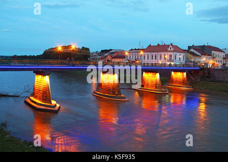 Beleuchtete Fußgängerbrücke in das Zentrum von Uzhgorod am Abend, Ukraine Stockfoto