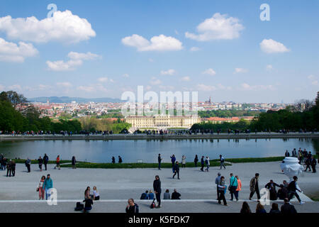 Wien, ÖSTERREICH - Apr 30th, 2017: Klassische Ansicht der berühmten Schloss Schönbrunn mit großem Parterre Garten mit Menschen zu Fuß an einem sonnigen Tag mit blauen Himmel und Wolken im Sommer. Der Palast ist eine ehemalige Kaiserliche 1441 - Zimmer Rokoko Sommerresidenz Sissi Kaiserin Elisabeth von Österreich Stockfoto