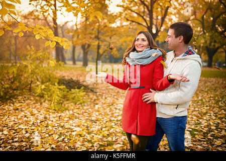 Romanze zwischen Männlichen und Weiblichen im Park mit gelben Blätter im Herbst Stockfoto