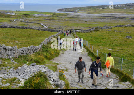 Touristen auf Fußweg zu Dun Aonghasa, eine prähistorische Stein fort, auf Inishmore Insel der Aran Gruppe, County Galway, Republik von Irland führenden Stockfoto