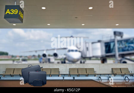 Flughafen Abflughalle, Flugzeug im unscharfen Hintergrund, Sommerurlaub Konzept, traveler Koffer im Flughafen Terminal Wartebereich Stockfoto