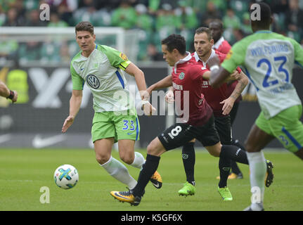 Wolfsburg, Deutschland. 9 Sep, 2017. Wolfsburg Mario Gomez (L) wird von der Hannover Manuel Schmiedebach (C) Während der Deutschen Bundesliga Fußball Spiel zwischen dem VfL Wolfsburg und Hannover 96 in der Volkswagen Arena in Wolfsburg, Deutschland, 9. September 2017 in Frage gestellt. (EMBARGO BEDINGUNGEN - ACHTUNG: Aufgrund der Akkreditierung Richtlinien, die DFL gestattet nur die Veröffentlichung und Verwertung von bis zu 15 Bildern pro Spiel im Internet und in online Medien während des Spiels.) Foto: Silas Stein/dpa/Alamy leben Nachrichten Stockfoto