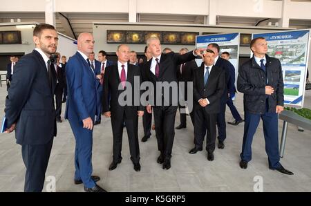 Der russische Präsident Wladimir Putin ist rund um das neu renovierte Luzhniki Grand Sports Arena durch Moskauer Bürgermeister Sergej Sobjanin, Abbildung rechts, und FIFA-Präsident Gianni Infantino, links, vor dem Start der FIFA World Cup Trophy Tour September 9, 2017 in Moskau, Russland. Stockfoto