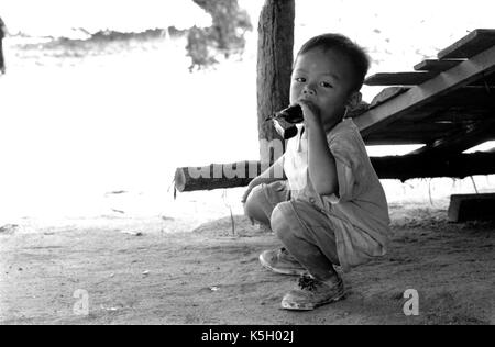 Karen burmesischen Flüchtlingskind Punkte eine Spielzeugpistole bei einem Camp im Nordwesten von Thailand. September, 1996. Stockfoto