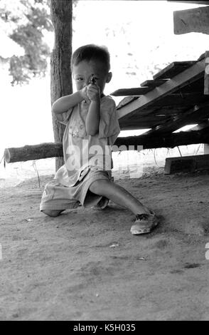 Karen burmesischen Flüchtlingskind Punkte eine Spielzeugpistole bei einem Camp im Nordwesten von Thailand. September, 1996. Stockfoto