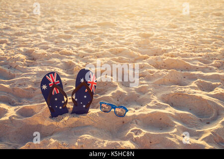 Tangas und Sonnenbrille im Sand am Strand, Australien Tag Konzept Stockfoto