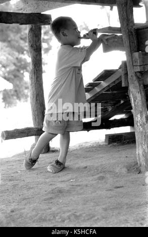 Eine junge, birmanischen Junge spielt mit einer Spielzeugpistole bei einem thailändischen Medècins Sans Frontiéres Krankenhaus in Mawker birmesische Flüchtlingslager im Nordwesten von Thailand. September, 1996. Stockfoto