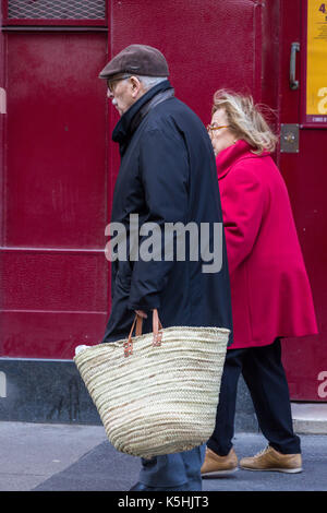 Ältere Paare gingen Hand in Hand auf der Straße, die man mit einem großen Shopping Bag, 7. Arrondissement, Paris, Frankreich Stockfoto