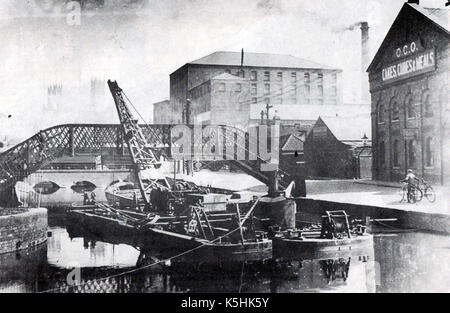 Lincoln England - schwimmbagger Ausbaggern der Fluss Witham in der Nähe eines dockside Mahlzeit Fabrik- und Lagerhallen. Stockfoto