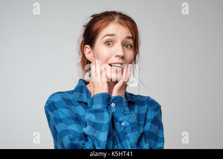 Portrait von überrascht Ginger weiblich lässig gekleidet in blauen T-Shirt, mit angehaltenem Atem. Stockfoto