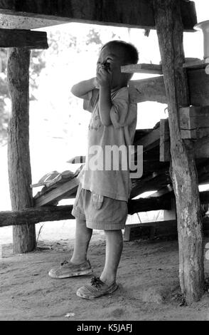 Karen burmesischen Flüchtlingskind Punkte eine Spielzeugpistole bei einem Camp im Nordwesten von Thailand. September, 1996. Stockfoto