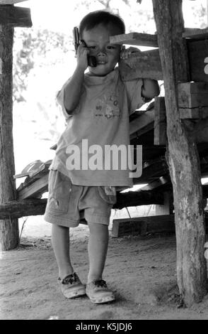 Eine junge, birmanischen Junge spielt mit einer Spielzeugpistole bei einem thailändischen Medècins Sans Frontiéres Krankenhaus in Mawker birmesische Flüchtlingslager im Nordwesten von Thailand. September, 1996. Stockfoto