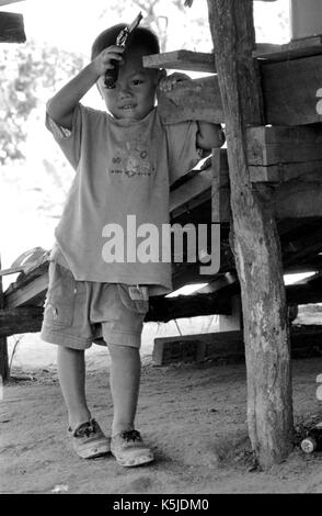 Eine junge, birmanischen Junge spielt mit einer Spielzeugpistole bei einem thailändischen Medècins Sans Frontiéres Krankenhaus in Mawker birmesische Flüchtlingslager im Nordwesten von Thailand. September, 1996. Stockfoto