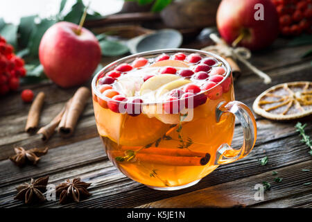 Winter Berry Tee mit Cranberries, Apfel, Zimt, Zitrone, Honig und Thymian in einem Glas Schale auf Holztisch. Horizontale, Detailansicht Stockfoto